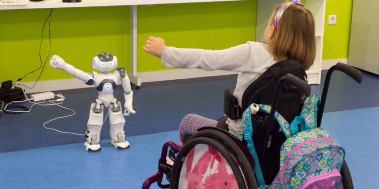 Una niña entrenando con con Robic, el Robot Humanoide.